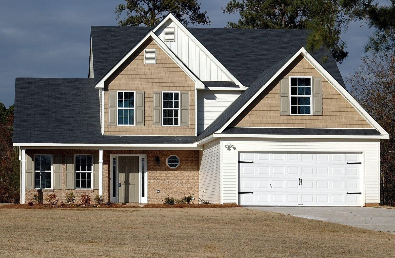 Two-storey house with a brick lower storey, shutters and a double garage