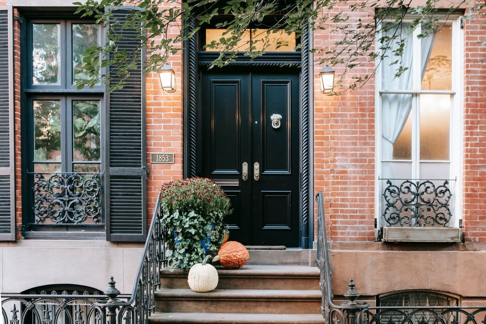 Black double front door with a transom on a red brick townhouse