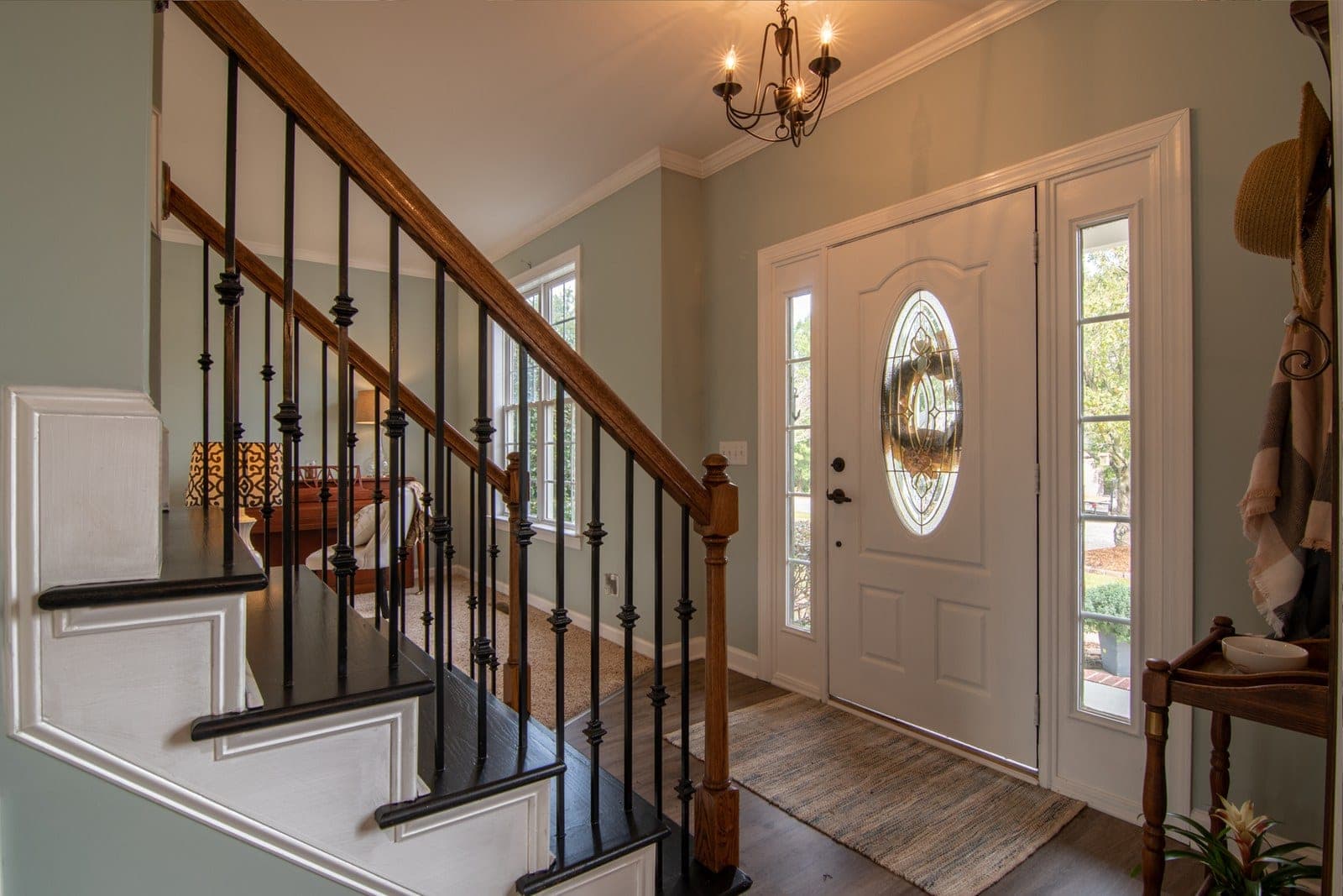 Front hall with a white entry door, oval glass and two sidelites