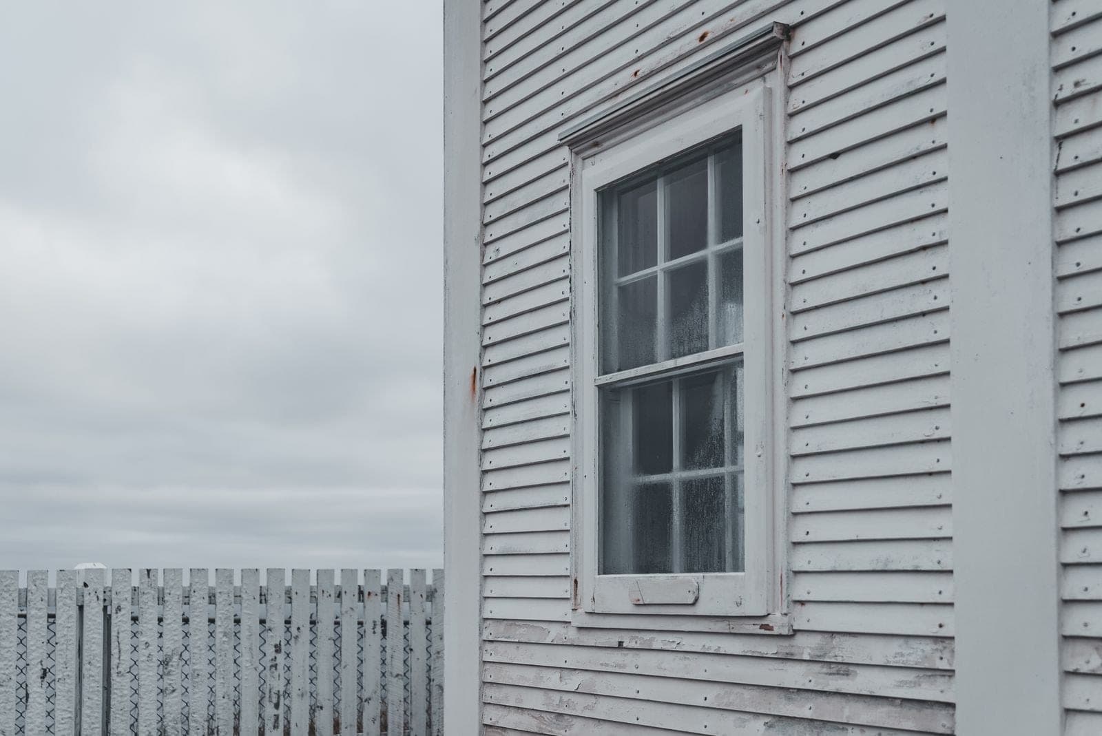 Old wood sash window in white clapboard siding