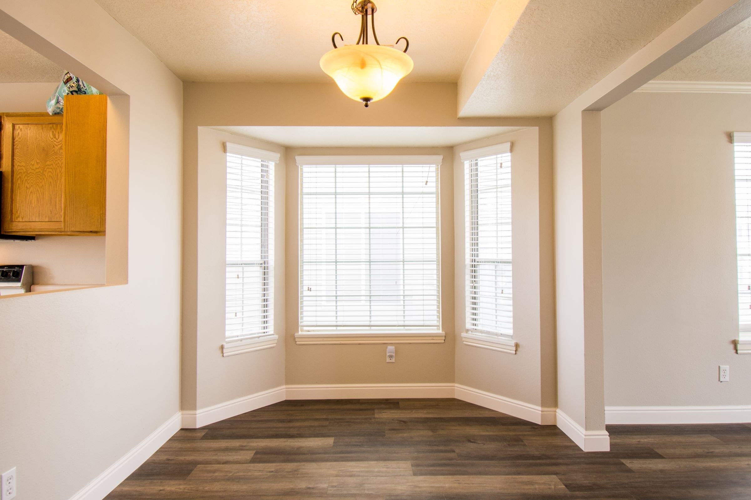 Bay window with three units and blinds in a dining nook