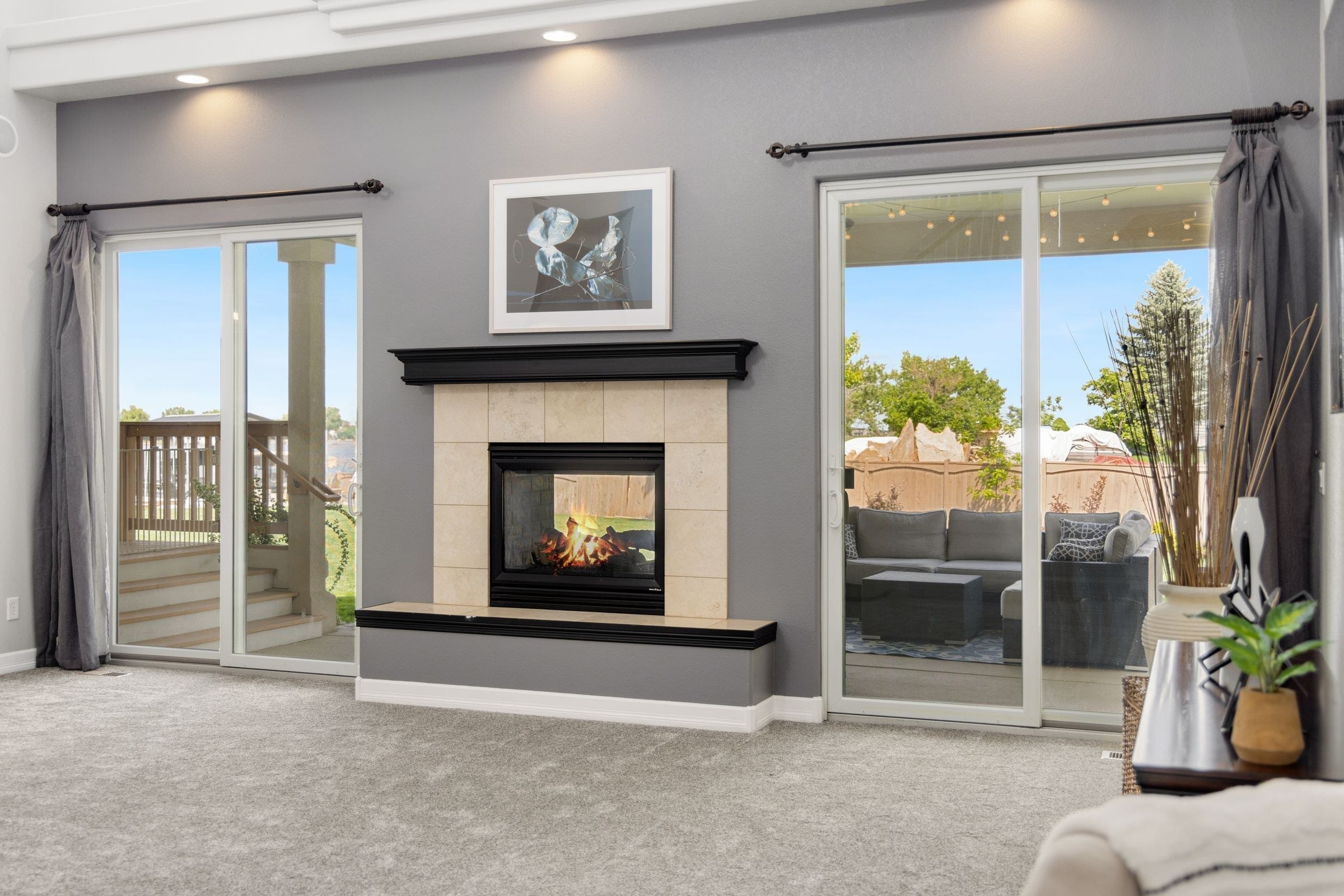 Living room with a sliding patio door on each side of a fireplace